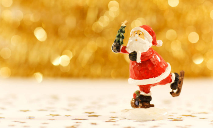Santa figurine ice skating with a christmas tree