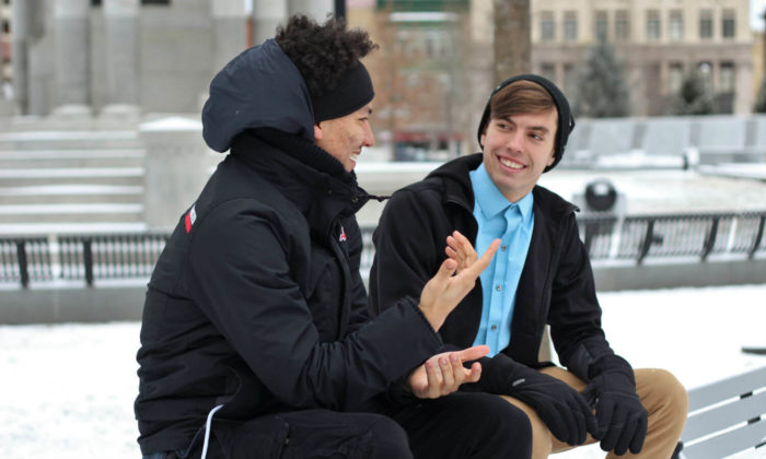 Two men sitting on benches outsides in winter talking