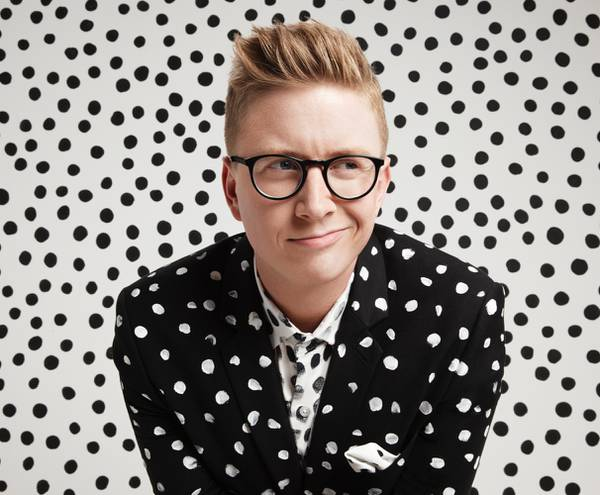 Tyler Oakley with a polka dot suit and background